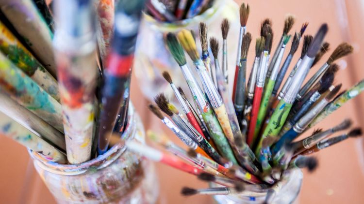 Bunte Pinsel in Becher für die Kunsttherapie