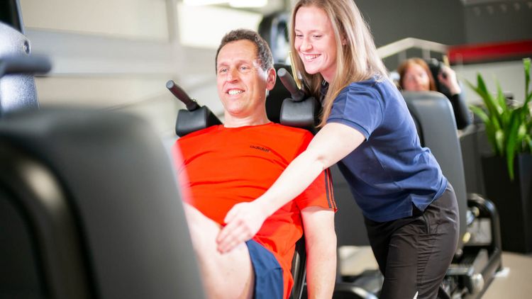 Therapeutin unterstützt Patient bei der Medizinischen Trainingstherapie