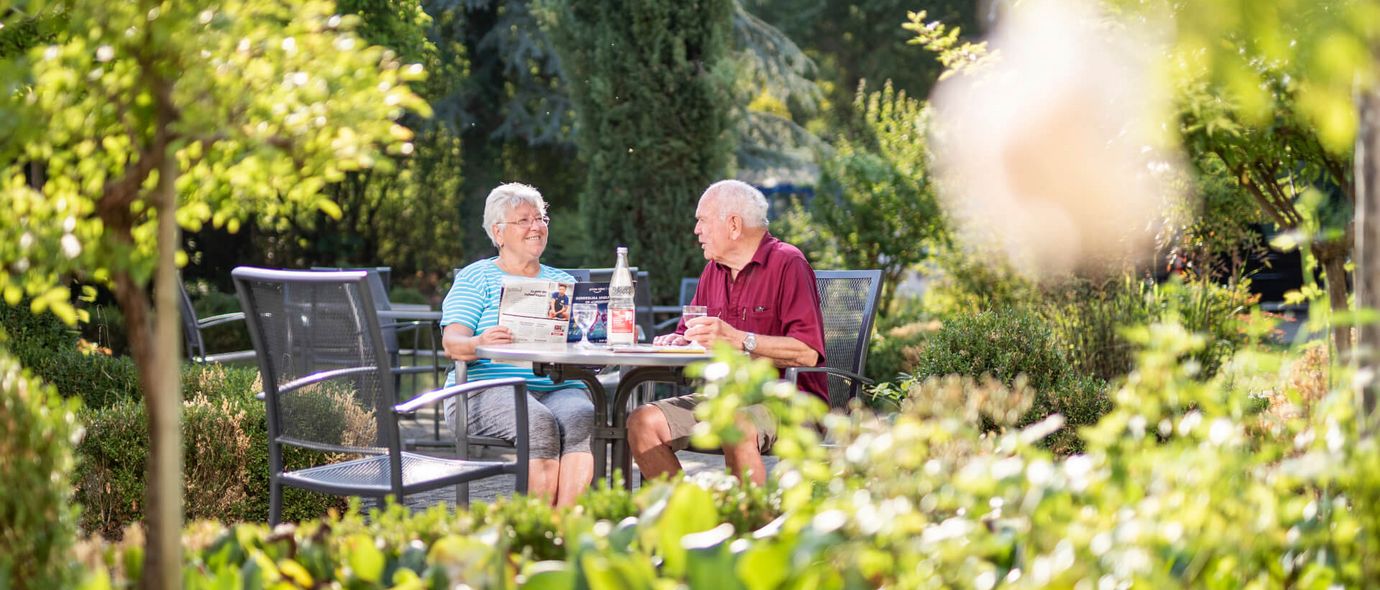 Patienten trinken Kaffee im Garten der Klinik