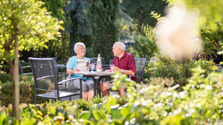 Patienten trinken Kaffee im Garten der Klinik