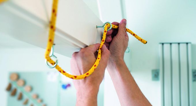 Patienten knotet Seil in der medizinisch-beruflich orienierten Rehabilitation