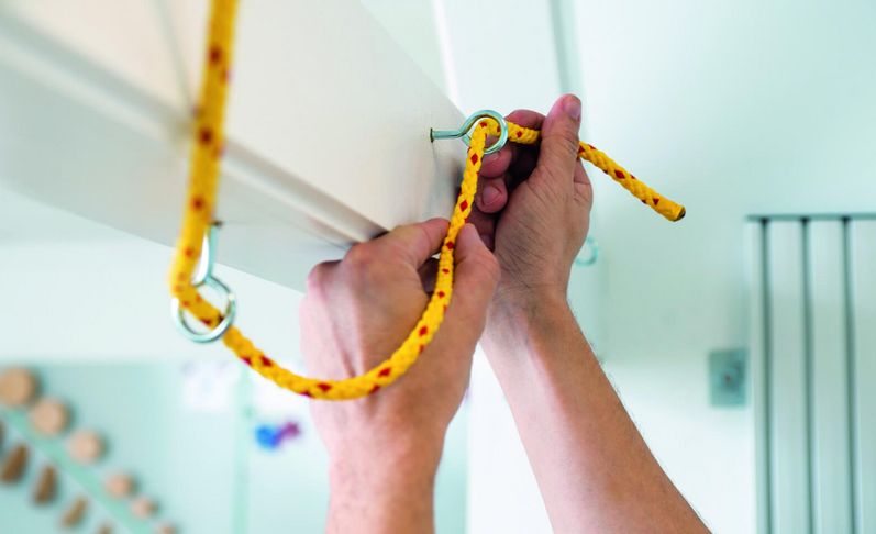 Patienten knotet Seil in der medizinisch-beruflich orienierten Rehabilitation