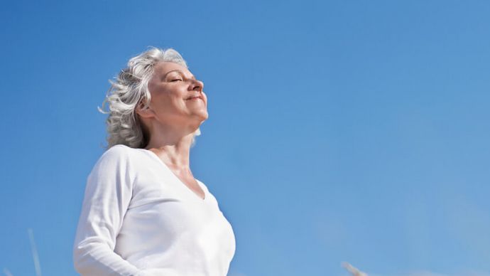 Grauhaarige Seniorin entspannt in der Sonne