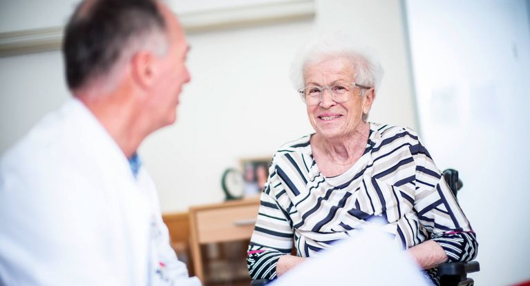 Arzt spricht mit Patientin in der Orthopädie