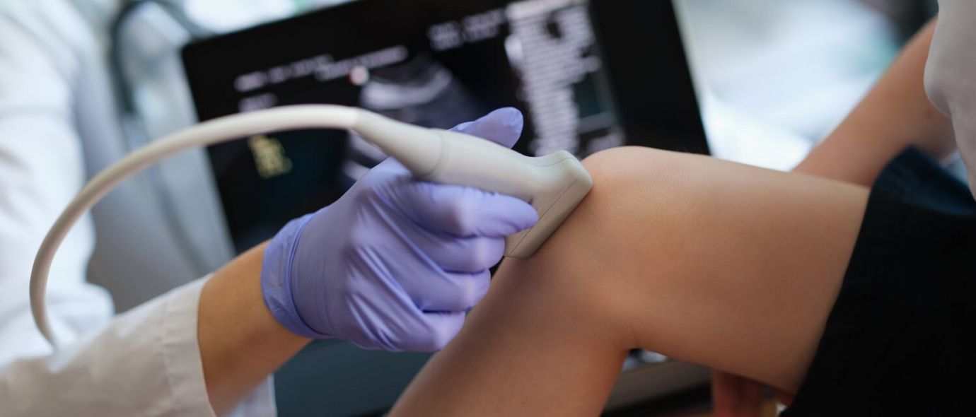 Arzt untersucht Kniegelenk mit Ultraschall